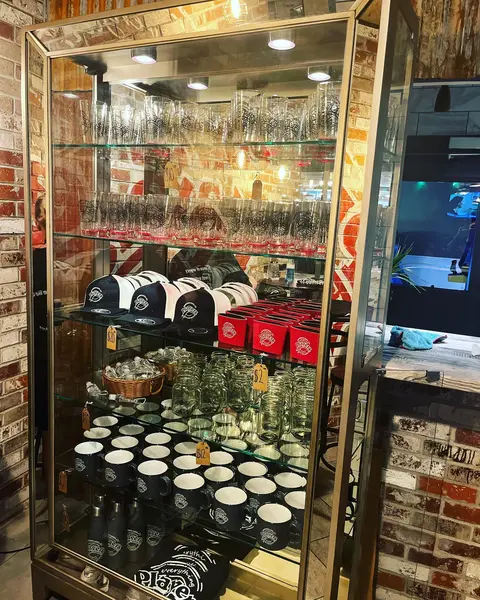 Glass case of Players Pizza mugs, caps and glassware