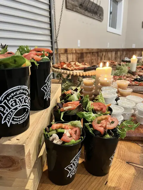 Fresh salads in black Players cups on a catered party table